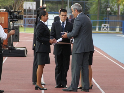 Sabas Chahuán entregando la condecoración "Ministerio Público" a los dos mejores alumnos de su generación