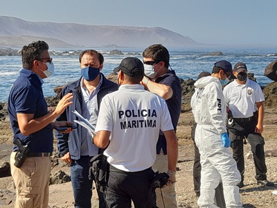 El fiscal jefe de Iquique, Gonzalo Guerrero, junto a personal de la Policía de Investigaciones y la Armada en el sitio del suceso.