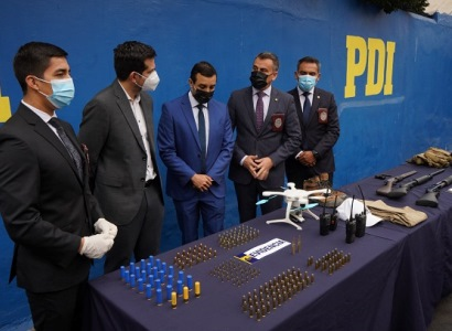 El fiscal de focos, Jaime Rojas (al centro) observa algunas municiones y armas incautadas en el marco de las investigaciones.