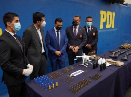 El fiscal de focos, Jaime Rojas (al centro) observa algunas municiones y armas incautadas en el marco de las investigaciones.